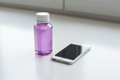 calpol bottle (unbranded but purple) next to a phone